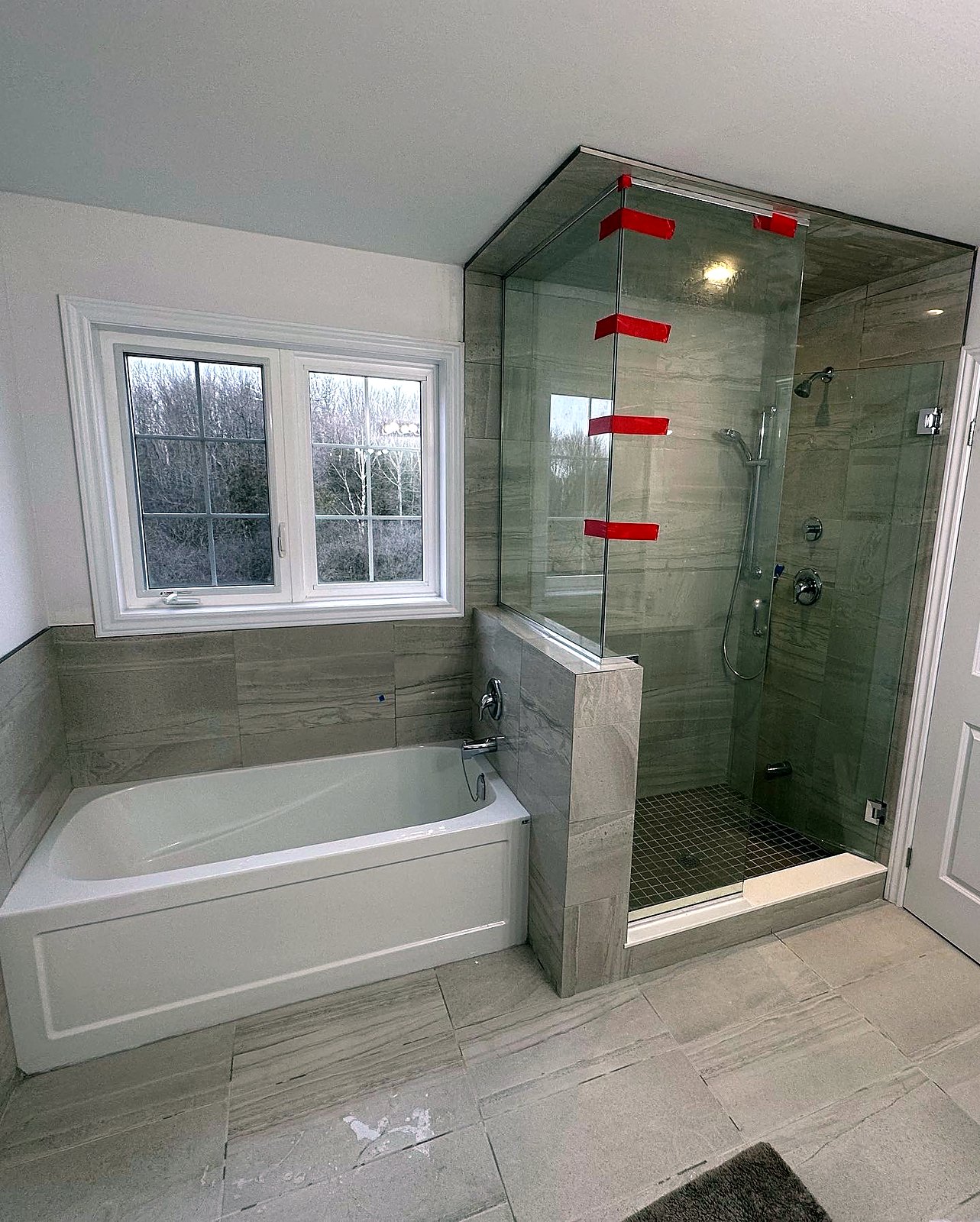 Finished bathroom with tiled tub surround and glass shower enclosure